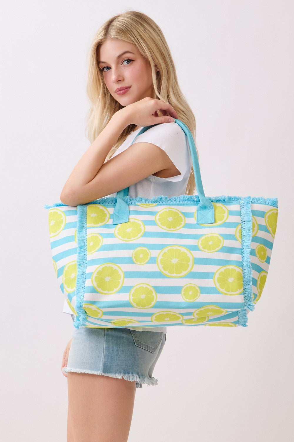 Woman holding a tote bag with lemon pattern on a white background