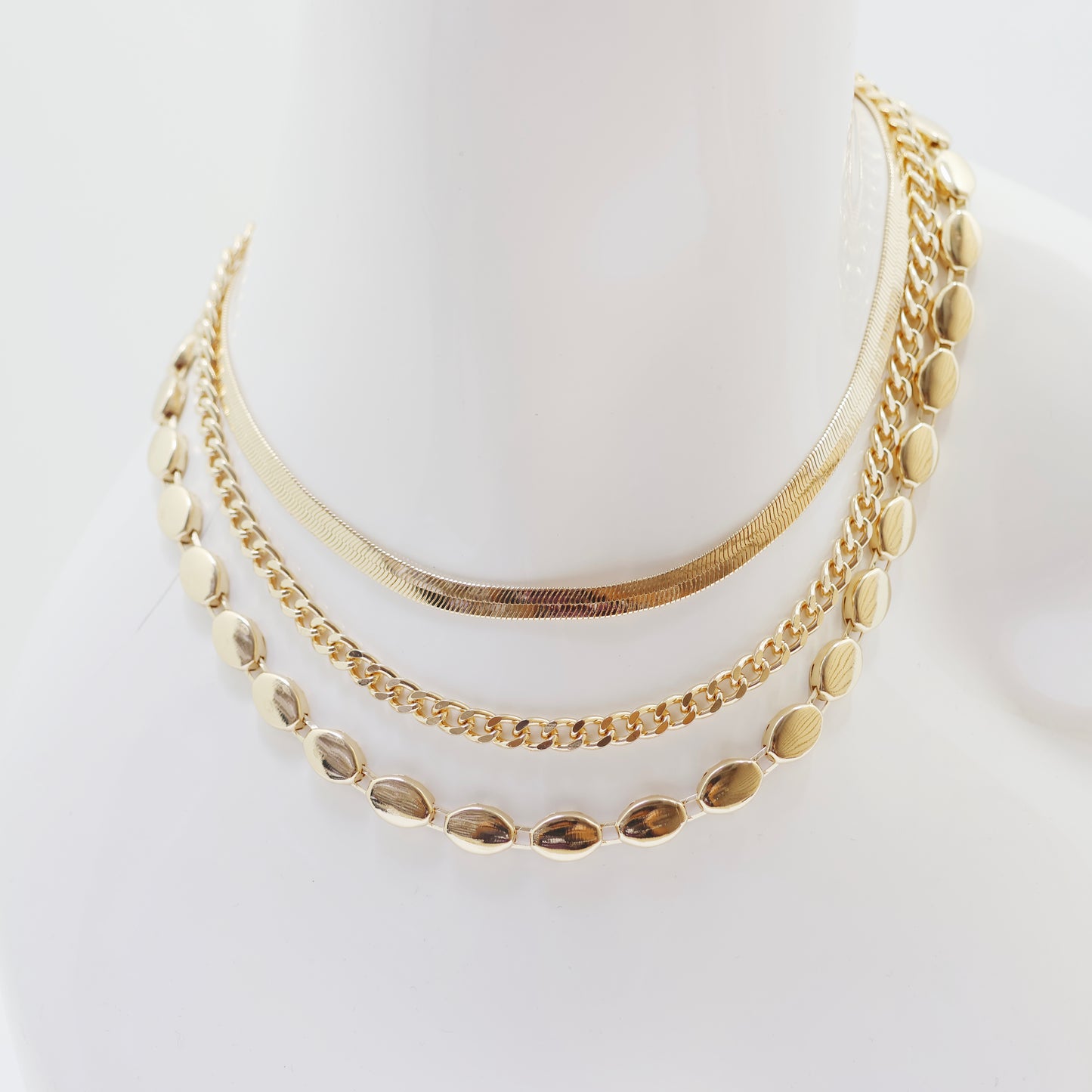 A classic gold necklace set on a white background