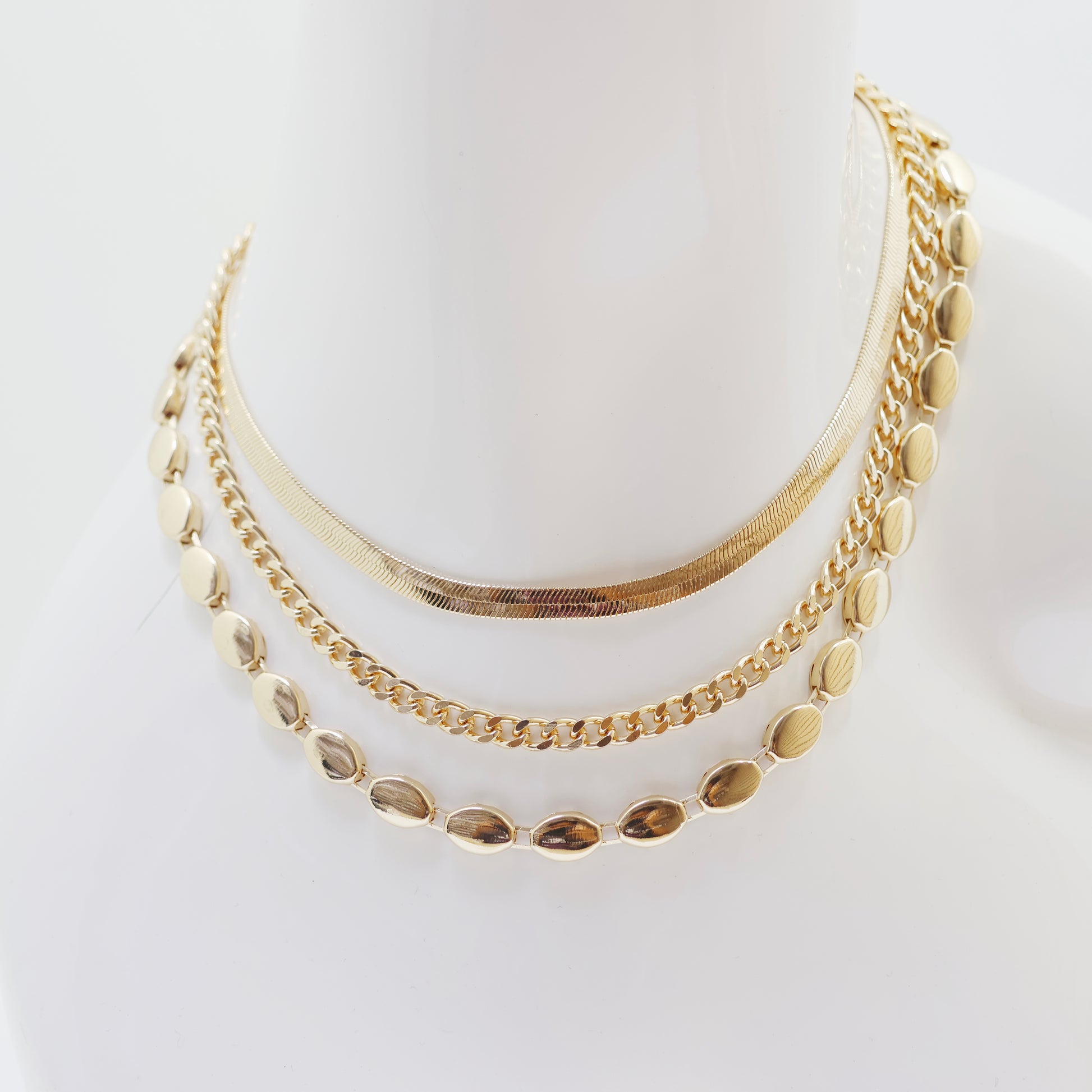 A classic gold necklace set on a white background