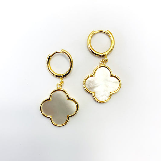 Hoop earrings with clover-shaped drop charms and polished trim in a chic boutique fashion style.