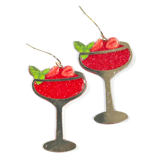 Martini glass earrings with red liquid and green olives on a white background