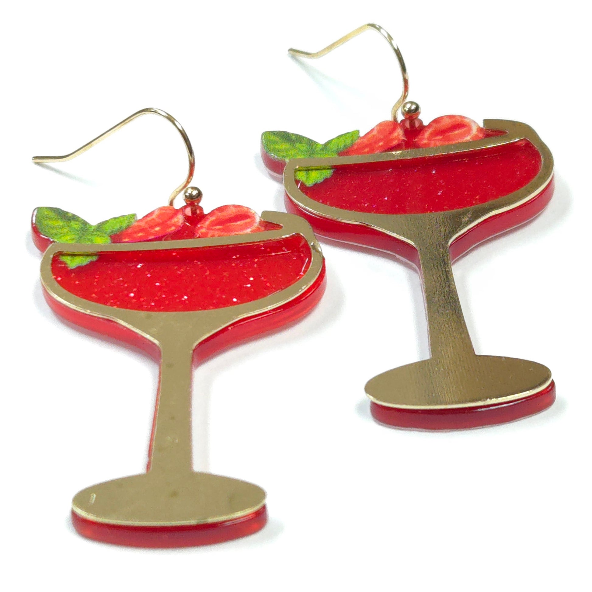 Red and gold cocktail glass earrings with strawberries on a white background