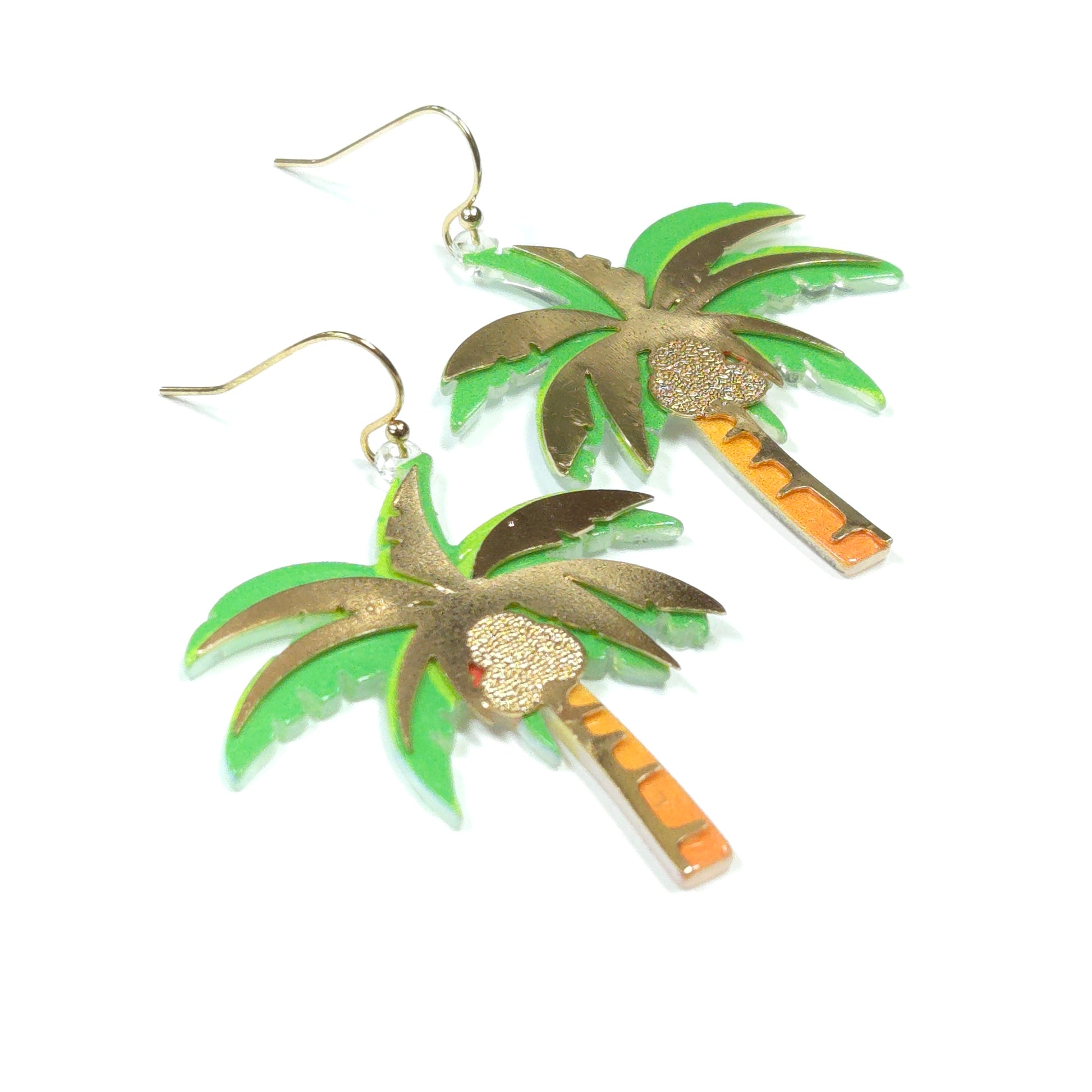 Pair of earrings with green and gold leaf-like design on a white background