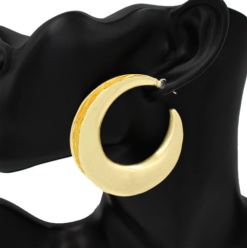 Gold crescent moon earring on a black mannequin