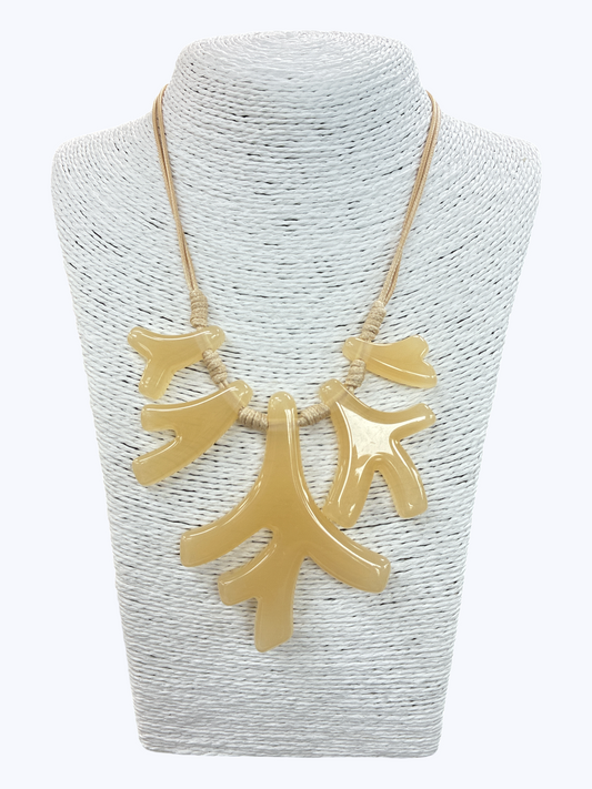 Beige coral branch statement necklace with glossy abstract pendant pieces and rope cord detail on mannequin display