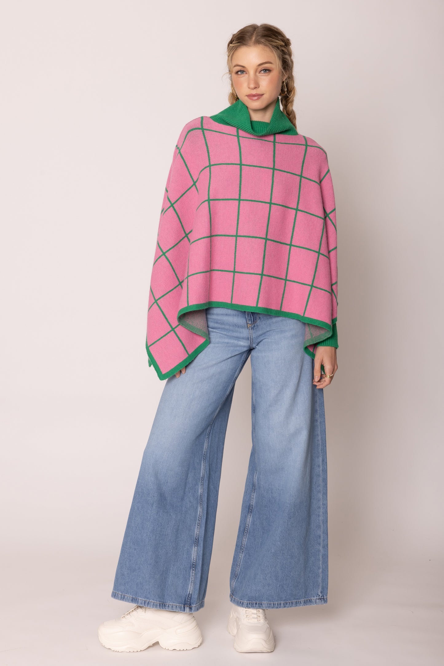 A pink poncho wears by a beautiful lady.