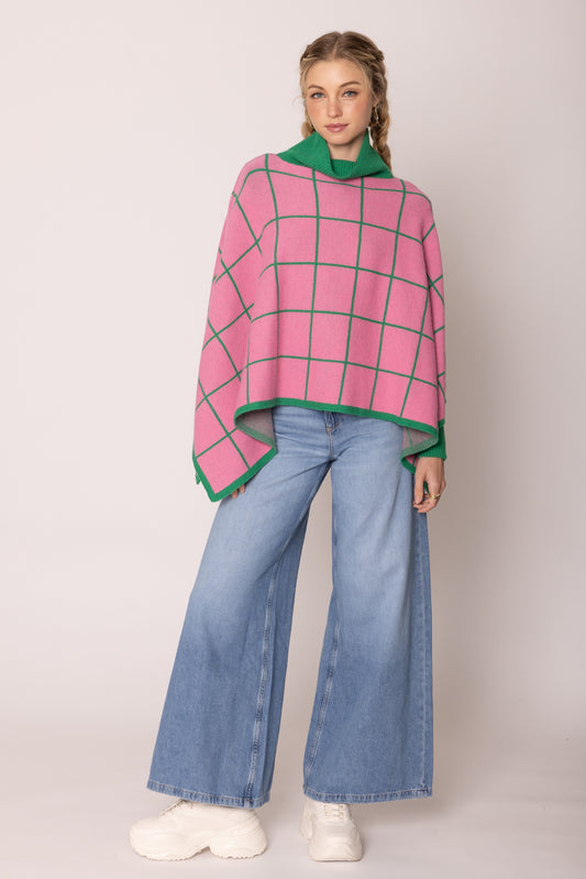 A pink poncho wears by a beautiful lady.