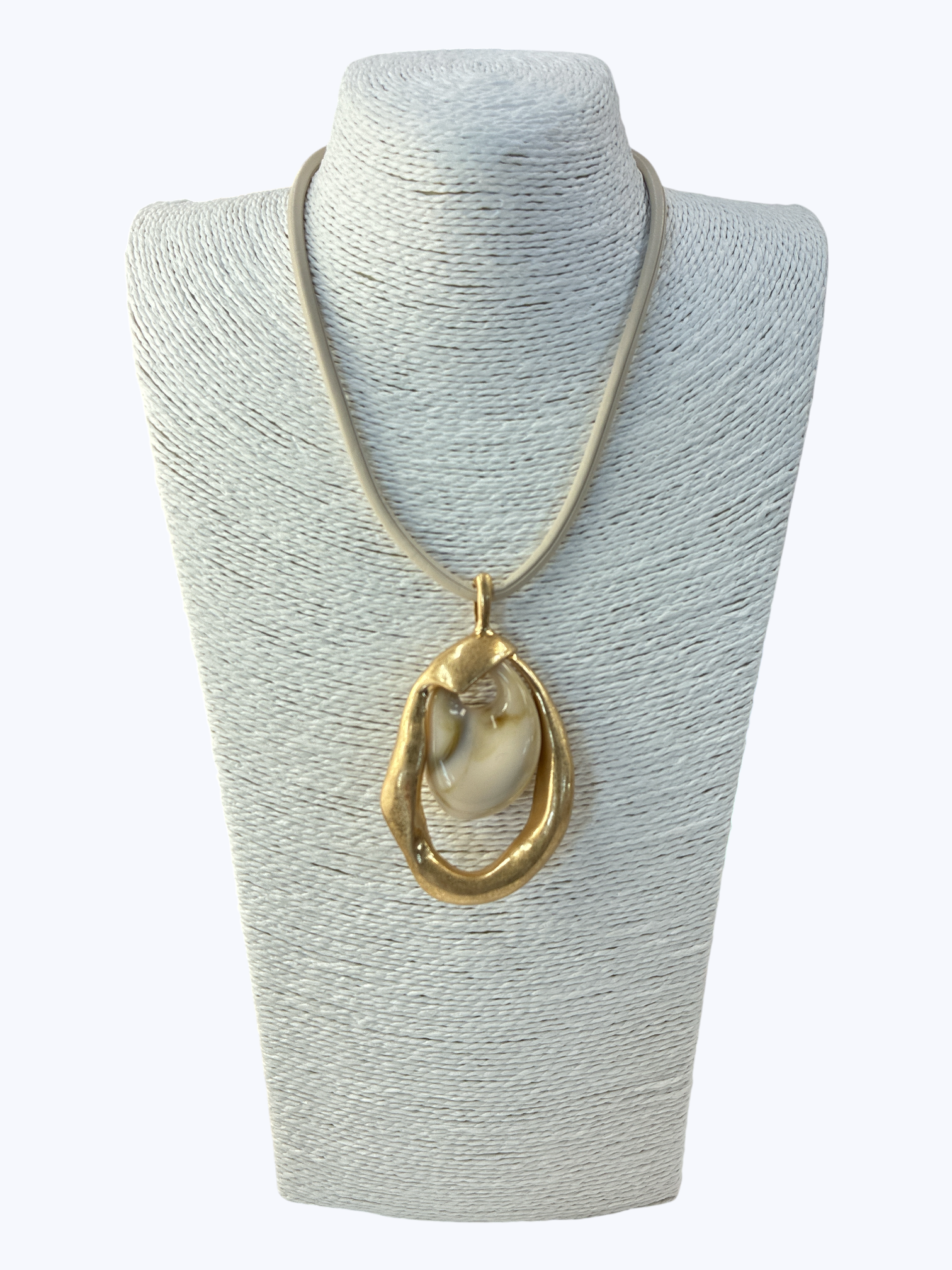 Necklace with a large gold pendant on a gray mannequin bust.