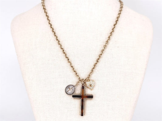 Necklace with cross pendant and round charm on a mannequin bust.