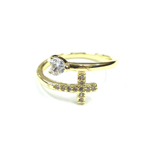 Gold ring with a diamond and cross design on a white background