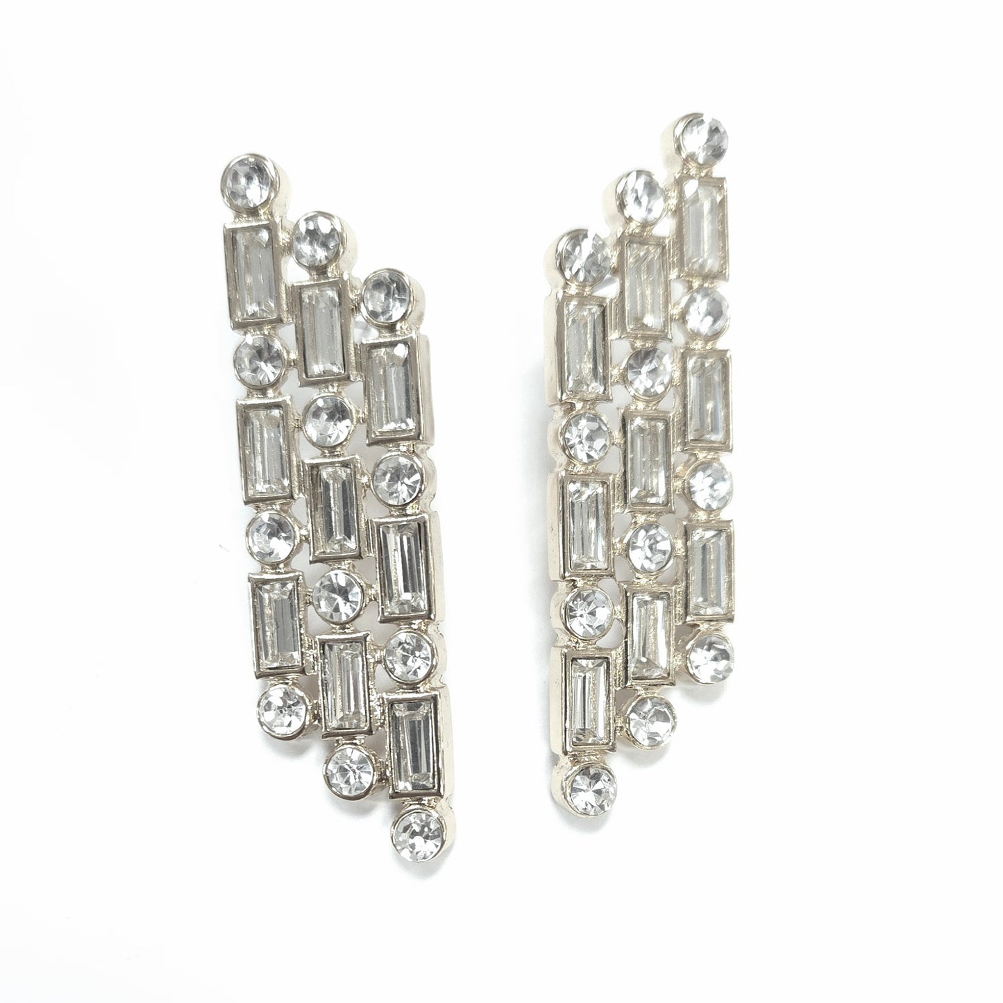 Pair of silver earrings with clear gemstones on a white background