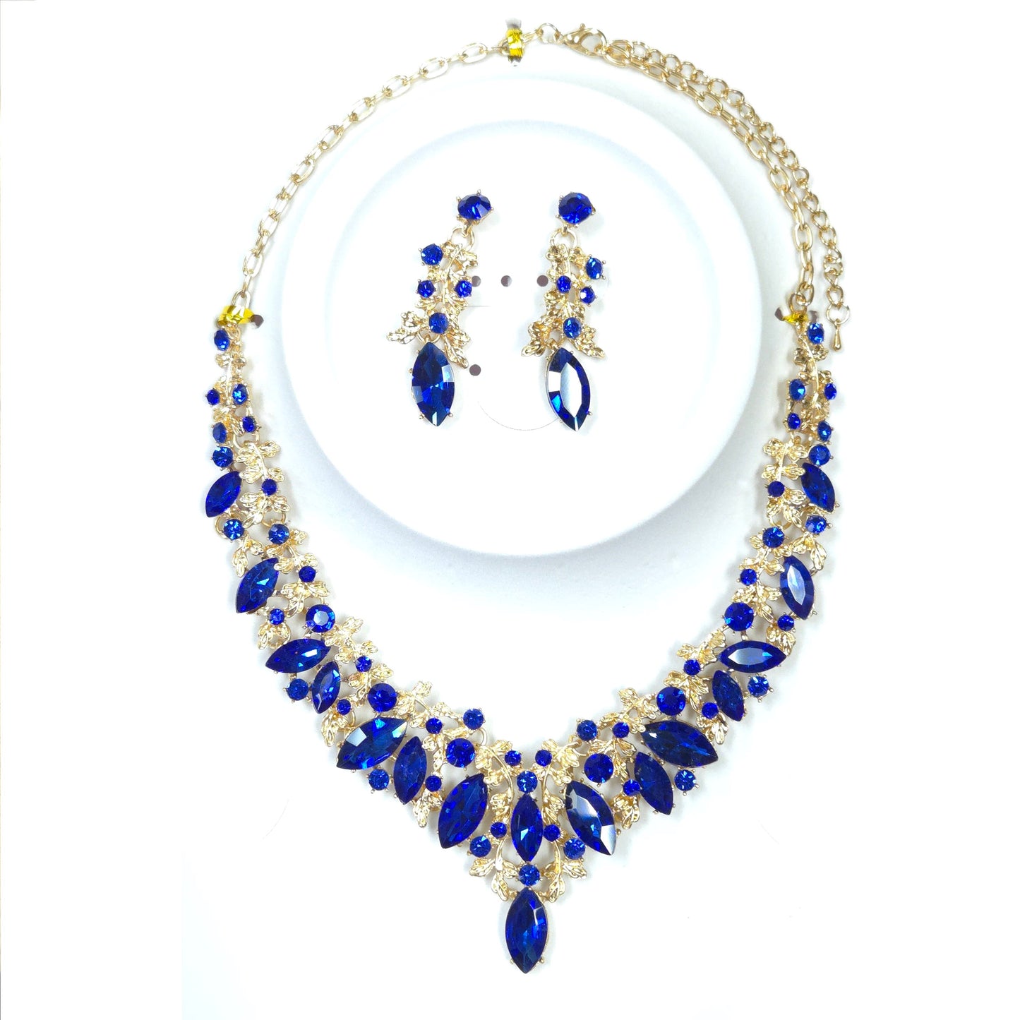 Jewelry set with blue and gold necklace and earrings on a white background