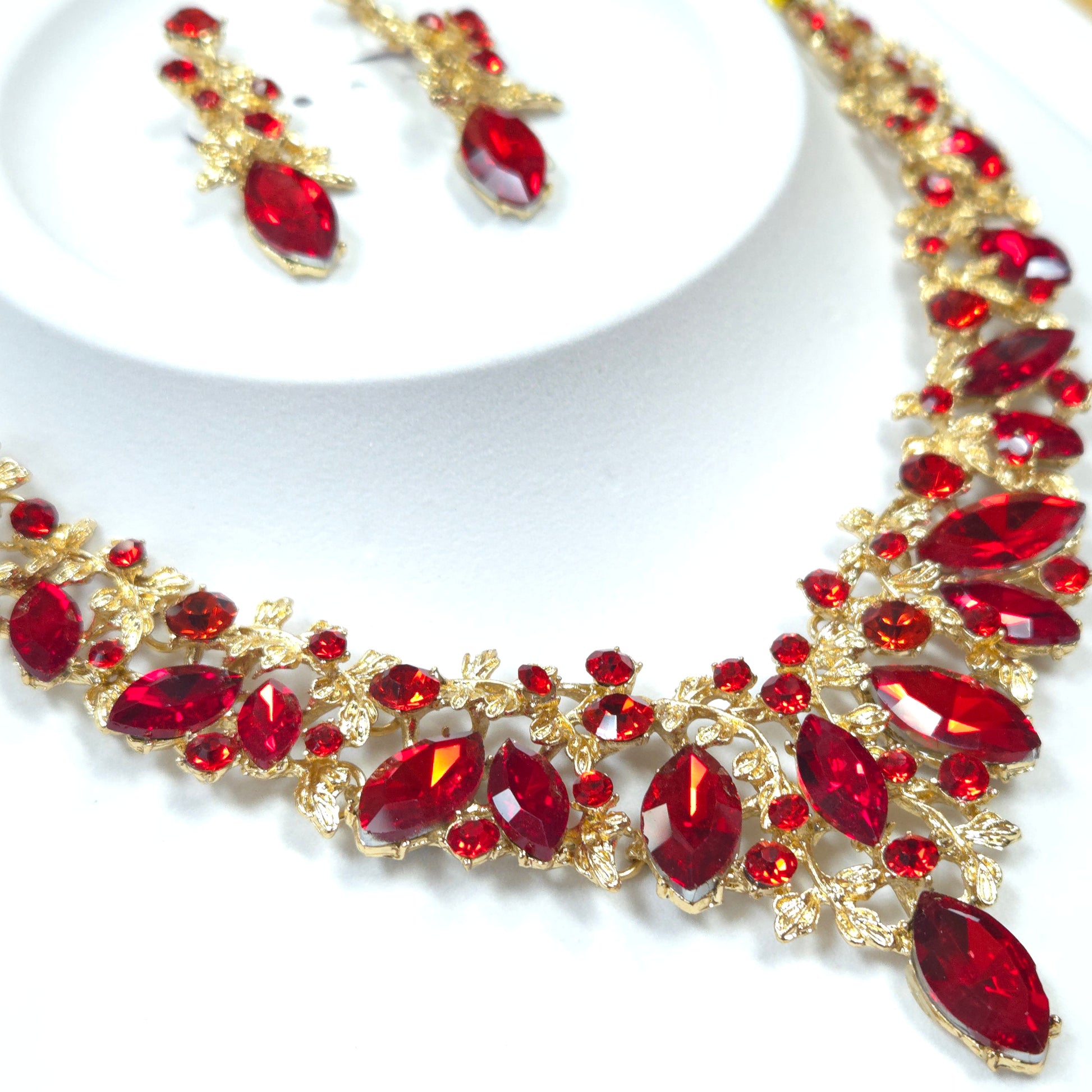 Jewelry set with red gemstones and gold accents on a white background