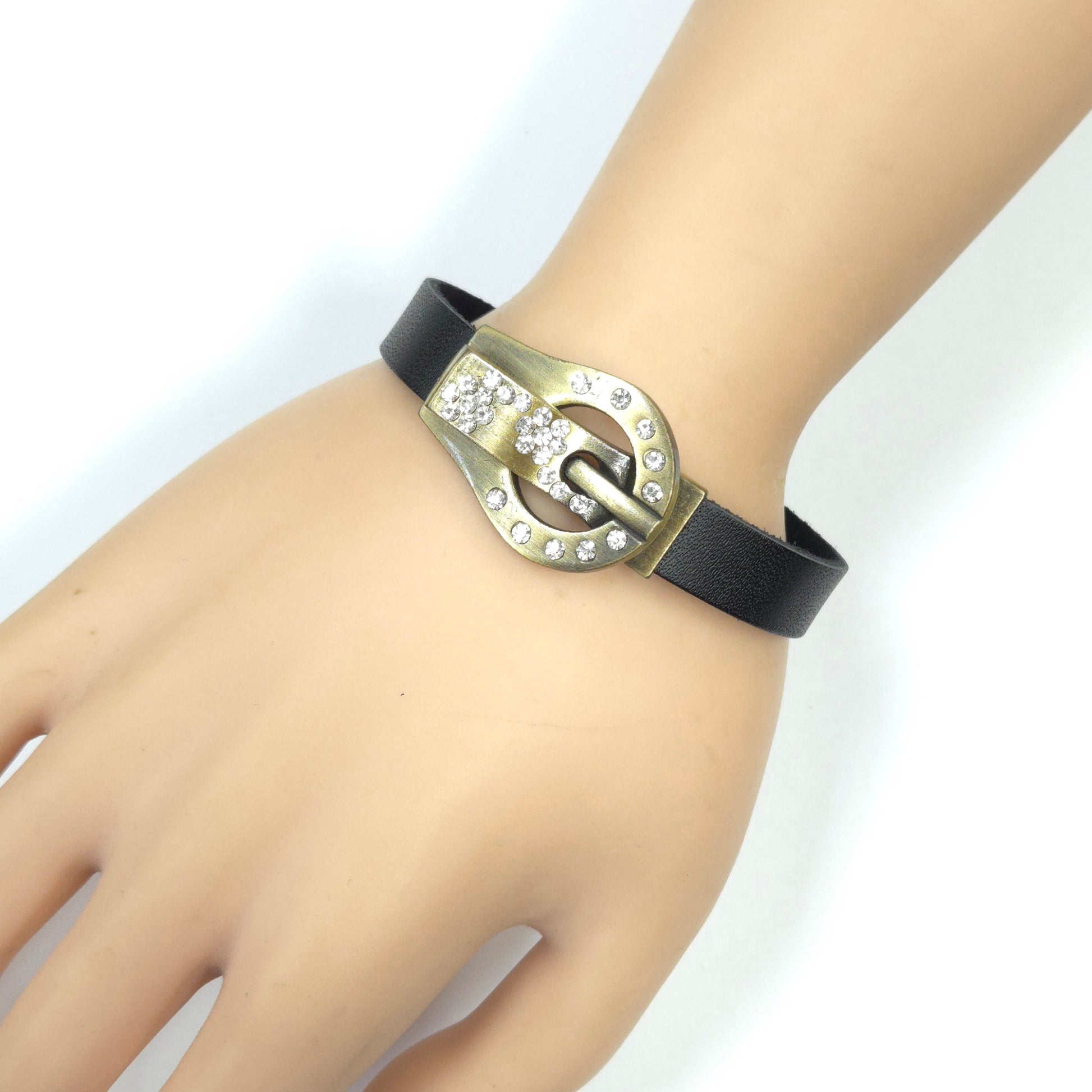 Black leather bracelet with a gold buckle on a mannequin wrist against a white background