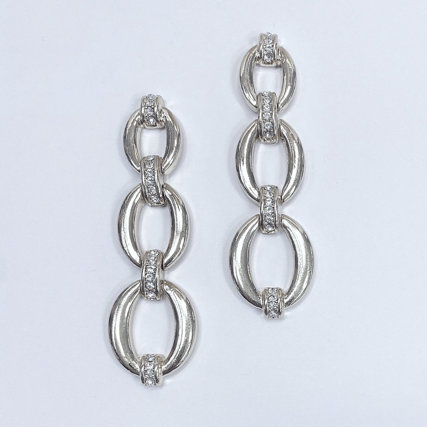 Triple oval shape linked drop dangle post earrings shown in gold tone and silver tone, displayed on a mannequin head.