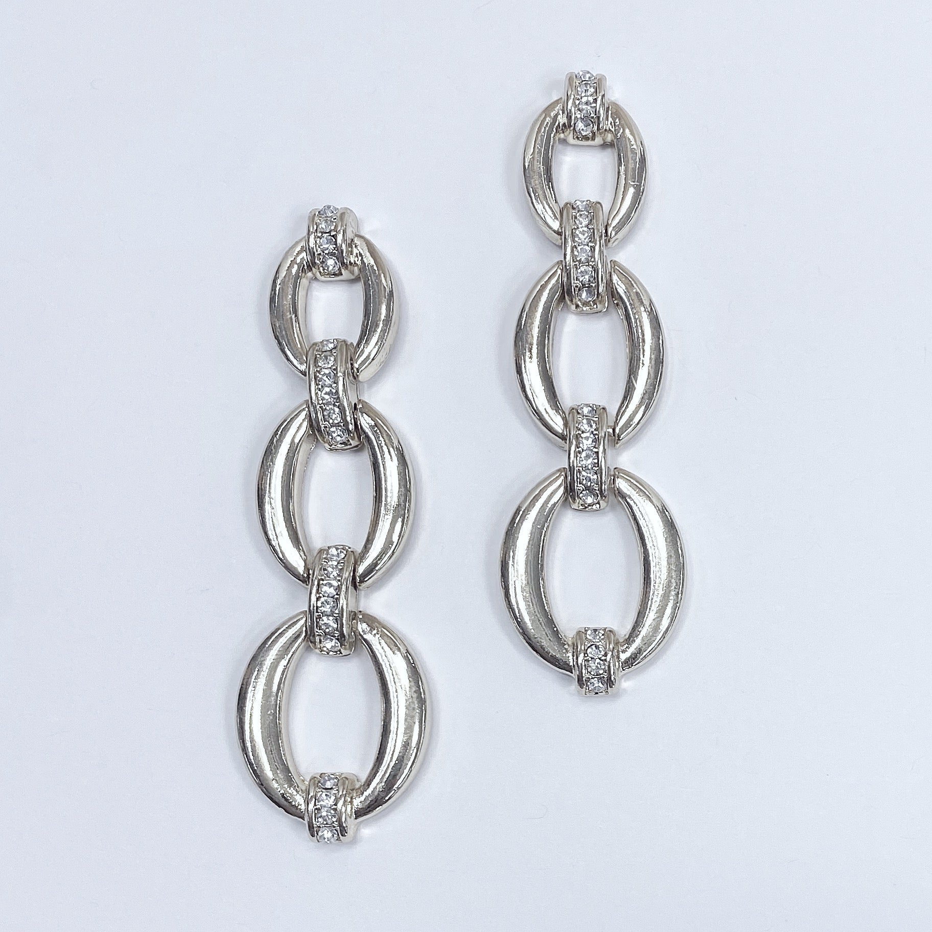 Triple oval shape linked drop dangle post earrings shown in gold tone and silver tone, displayed on a mannequin head.