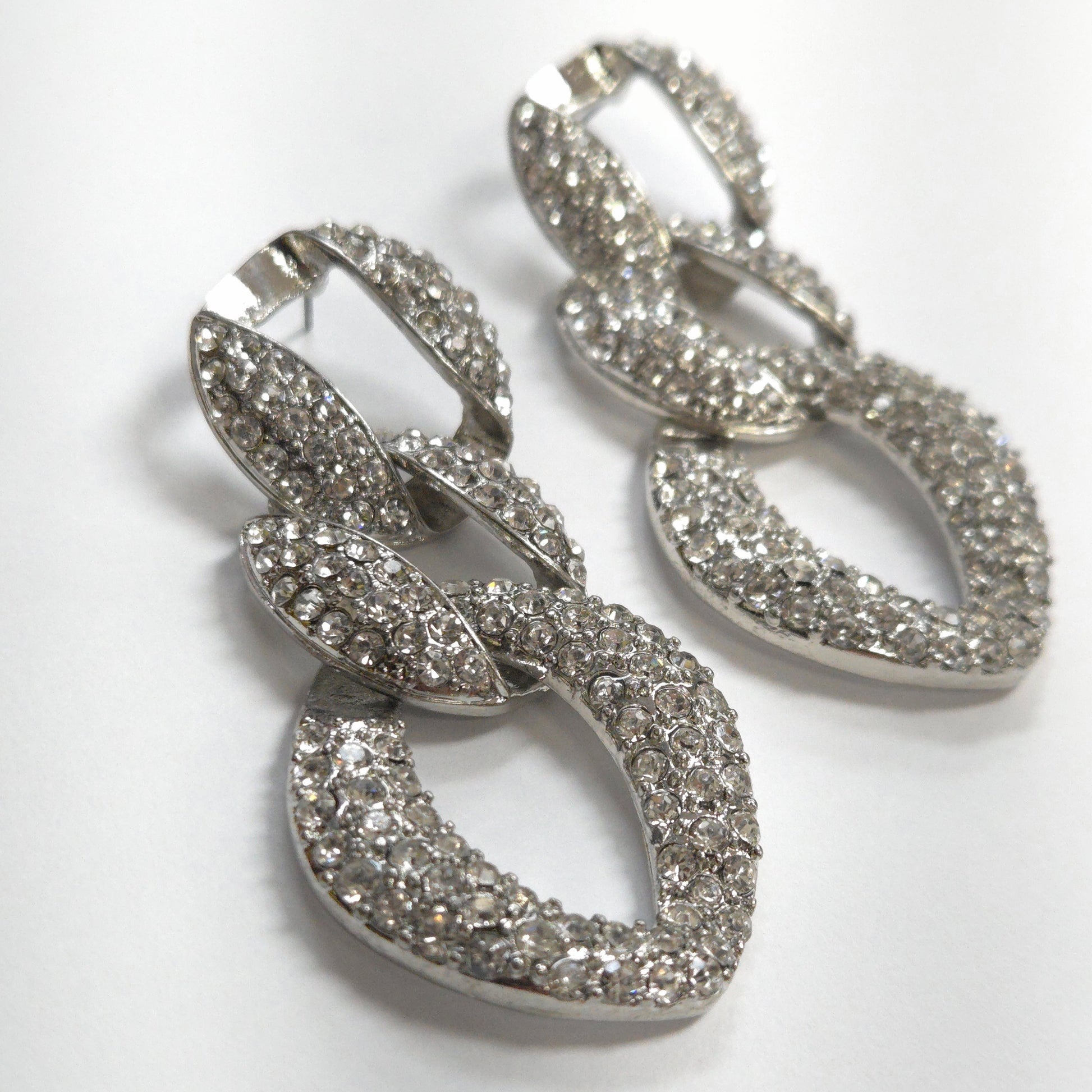 Silver hoop earrings with intricate detailing on a white background