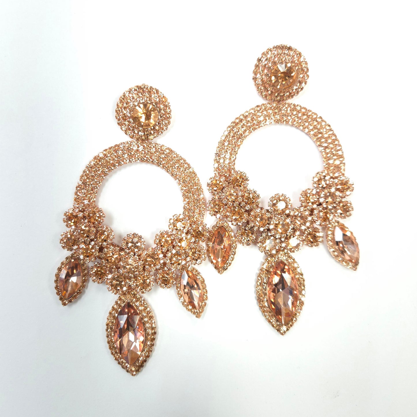 Gold chandelier earrings with gemstones on a light gray background