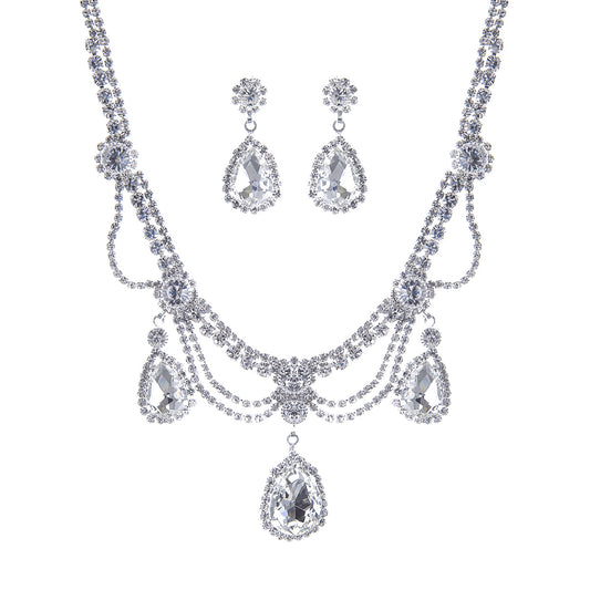 Silver necklace and earrings set on a white background