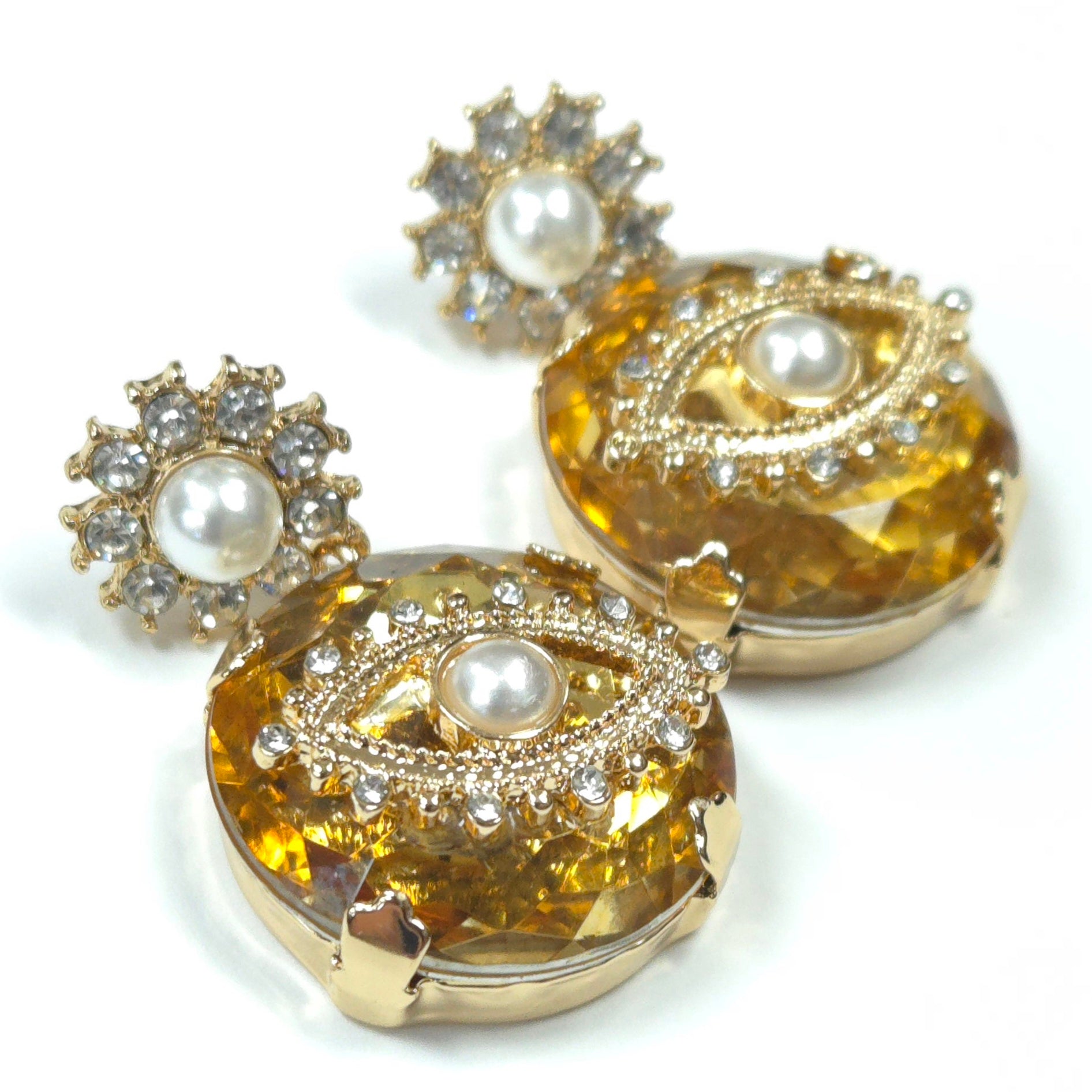 Gold earrings with pearl and gemstone accents on a white background