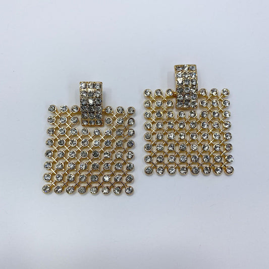 A pair of rectangular, gold-colored dangle earrings adorned with rhinestones.