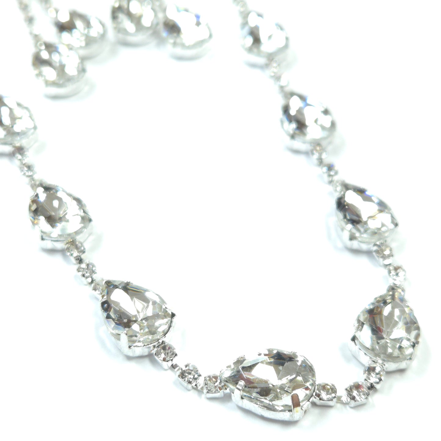 Silver bracelet with clear gemstones on a white background