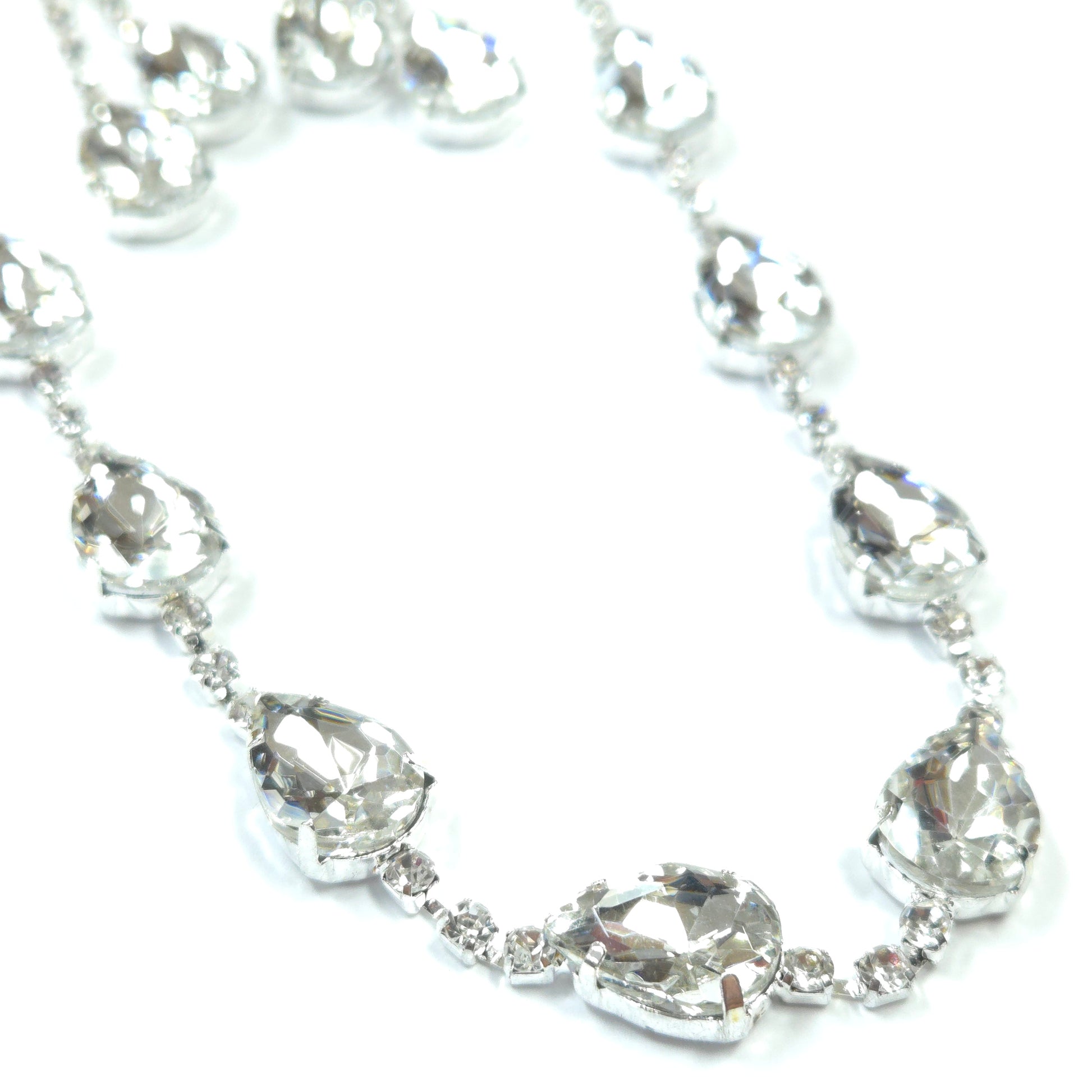 Silver bracelet with clear gemstones on a white background