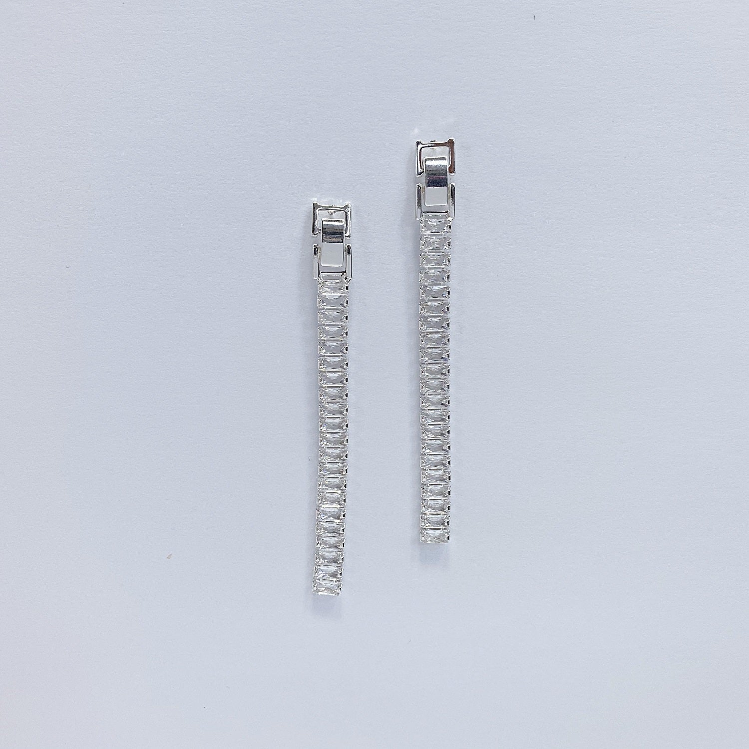 A set of rhinestone drop dangle post earrings with post back closure, displayed in gold and silver colors.