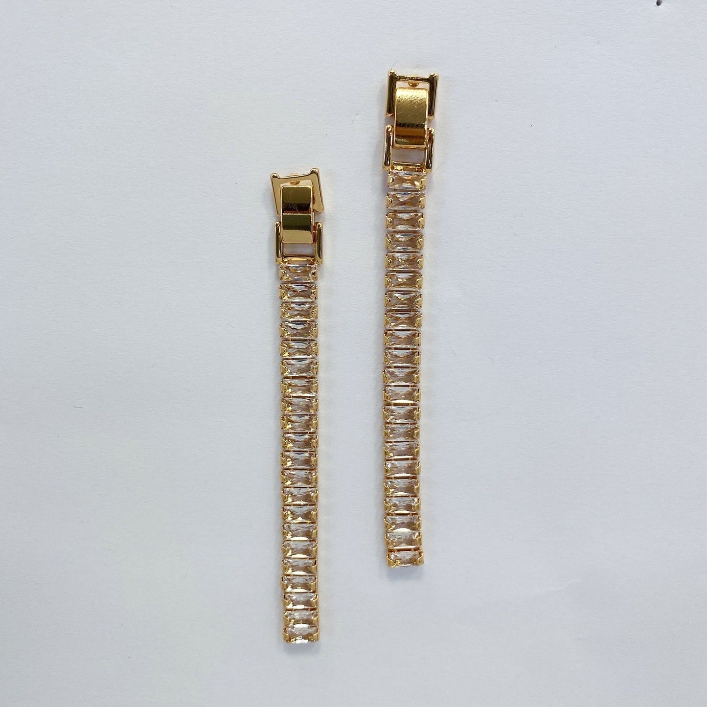 A set of rhinestone drop dangle post earrings with post back closure, displayed in gold and silver colors.