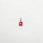 Silver pendant with a red gemstone on a white background