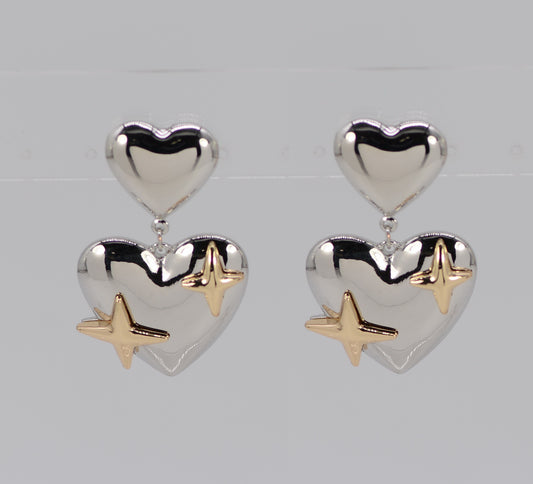Heart-shaped earrings with gold star accents on a light gray background