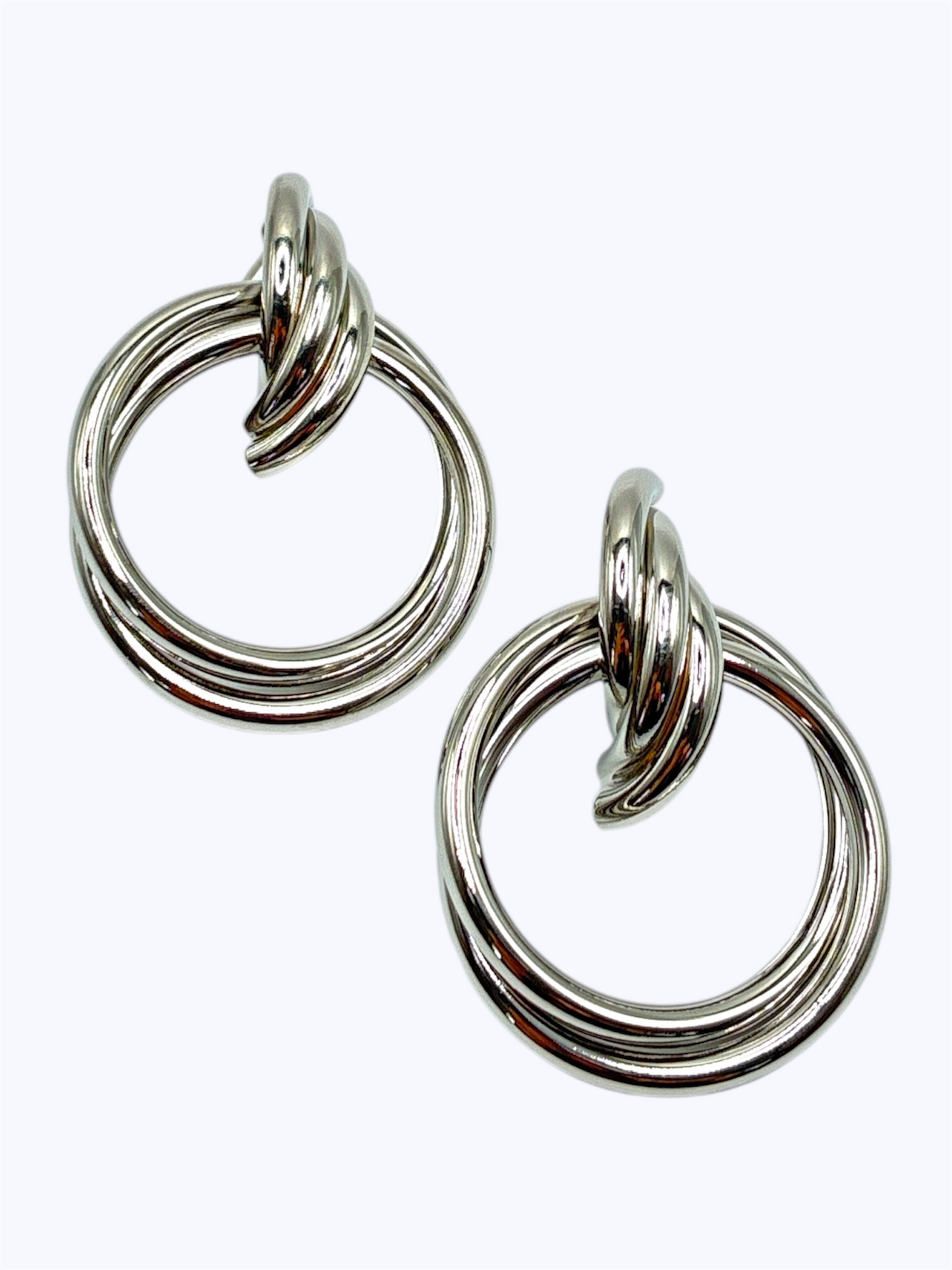 Shiny silver knot hoop earrings featuring a sleek triple-ring circle design with a modern minimalist look