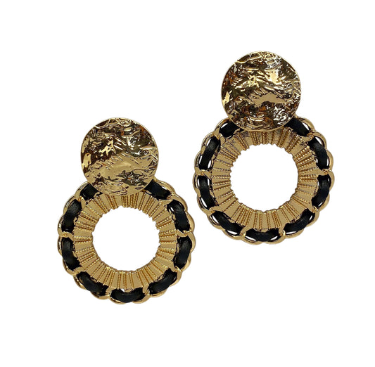 A pair of gold earrings inspired by Egyptians sculptures on a white background