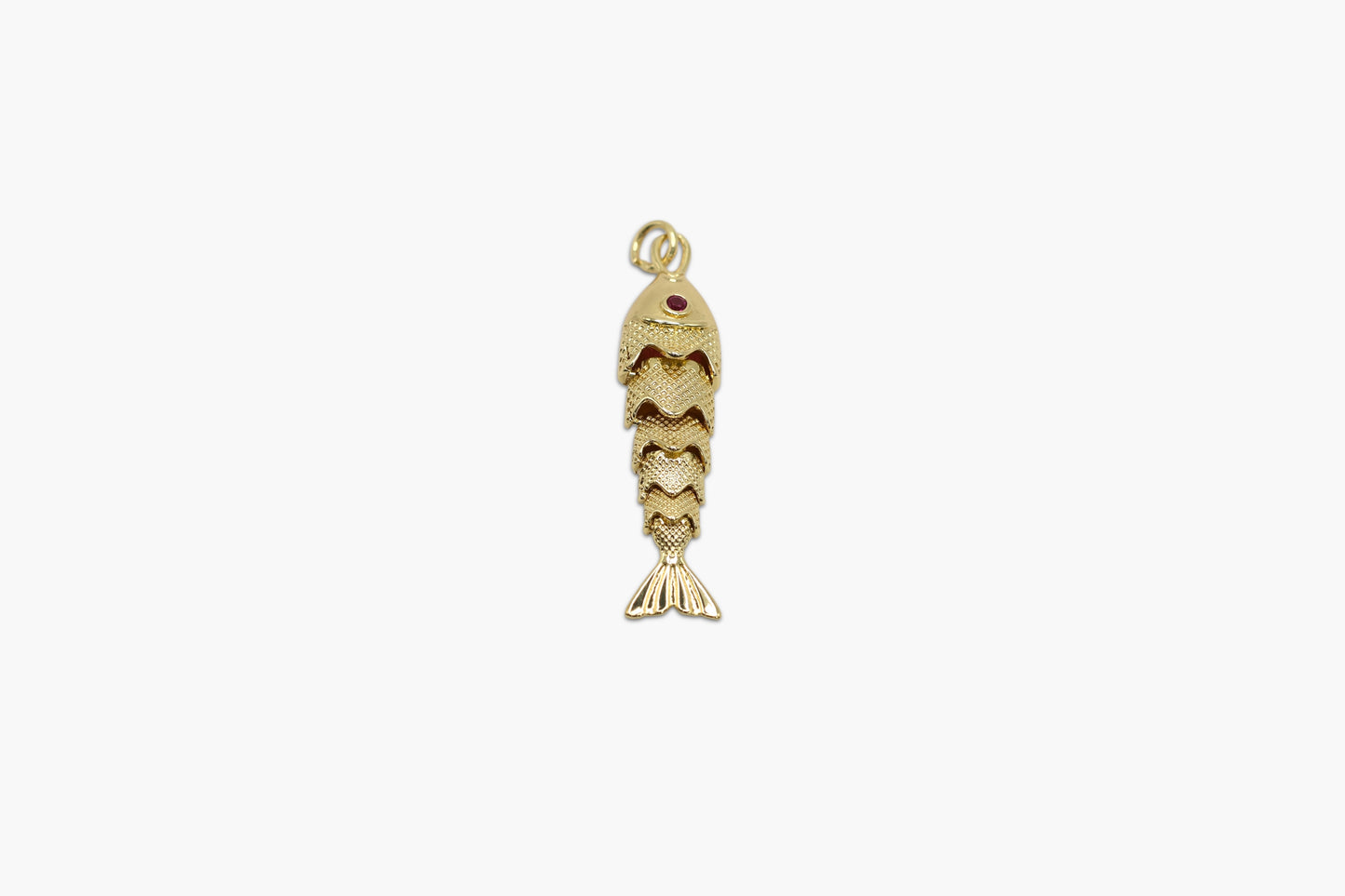 Gold fish-shaped pendant on a white background