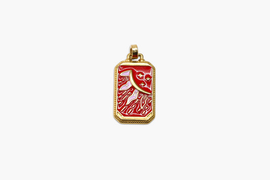 Gold pendant with red design on a white background