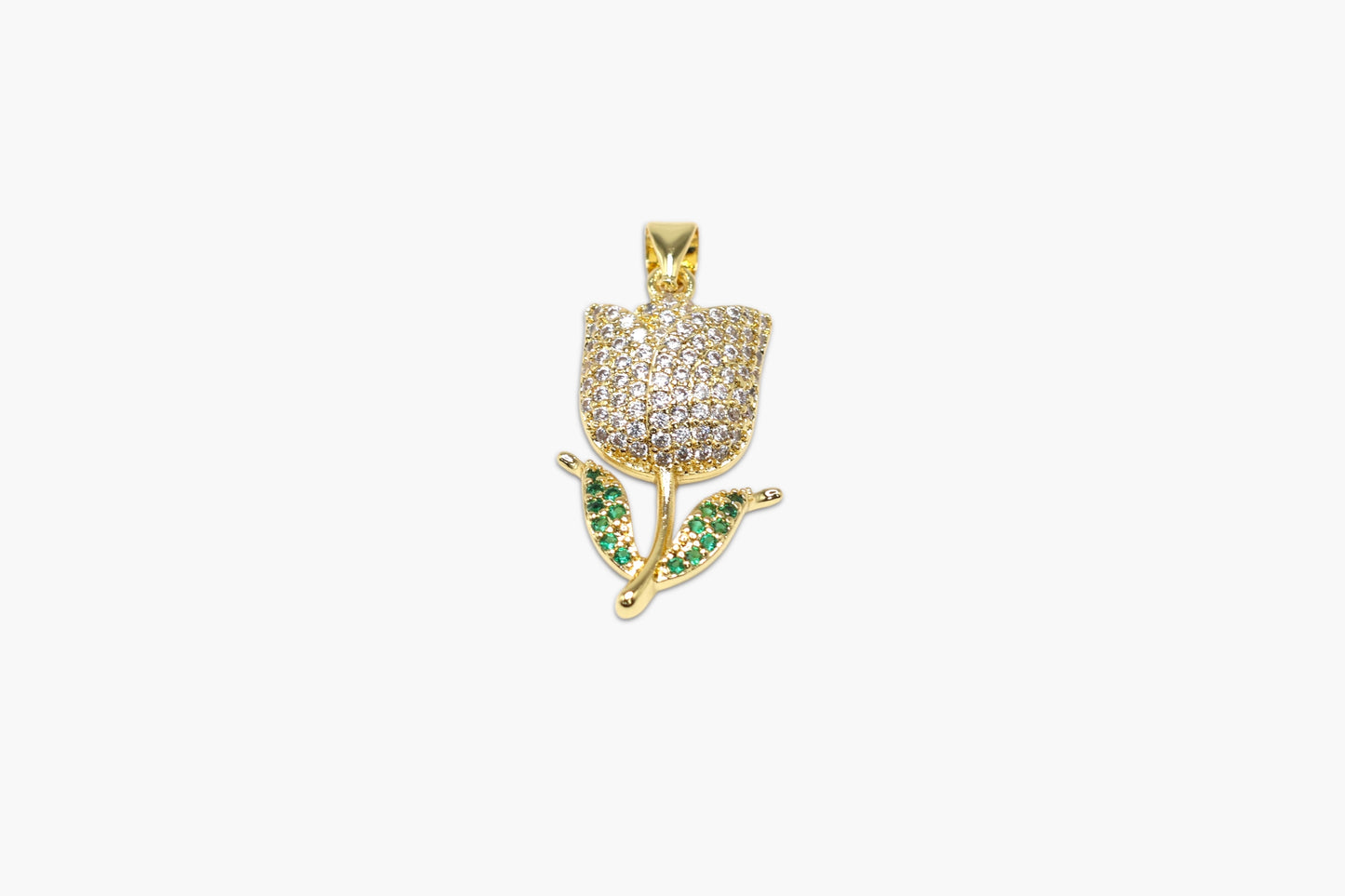 Gold pendant with green gemstones on a white background