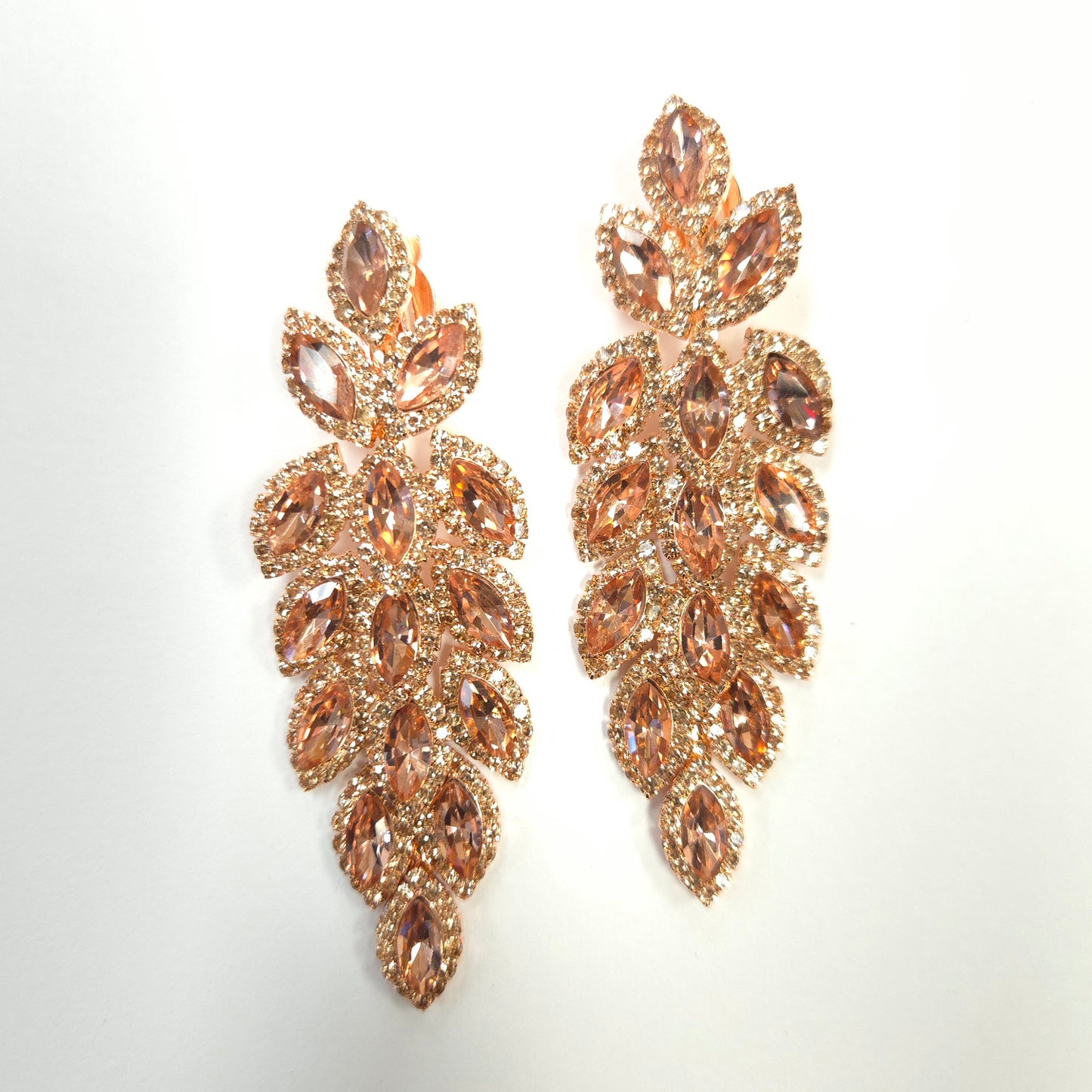 Rose gold leaf-shaped earrings on a light gray background