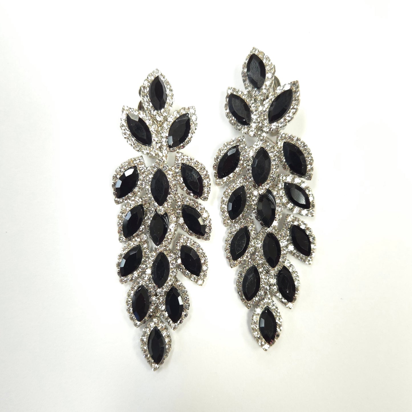 Pair of black and silver leaf-shaped earrings on a white background