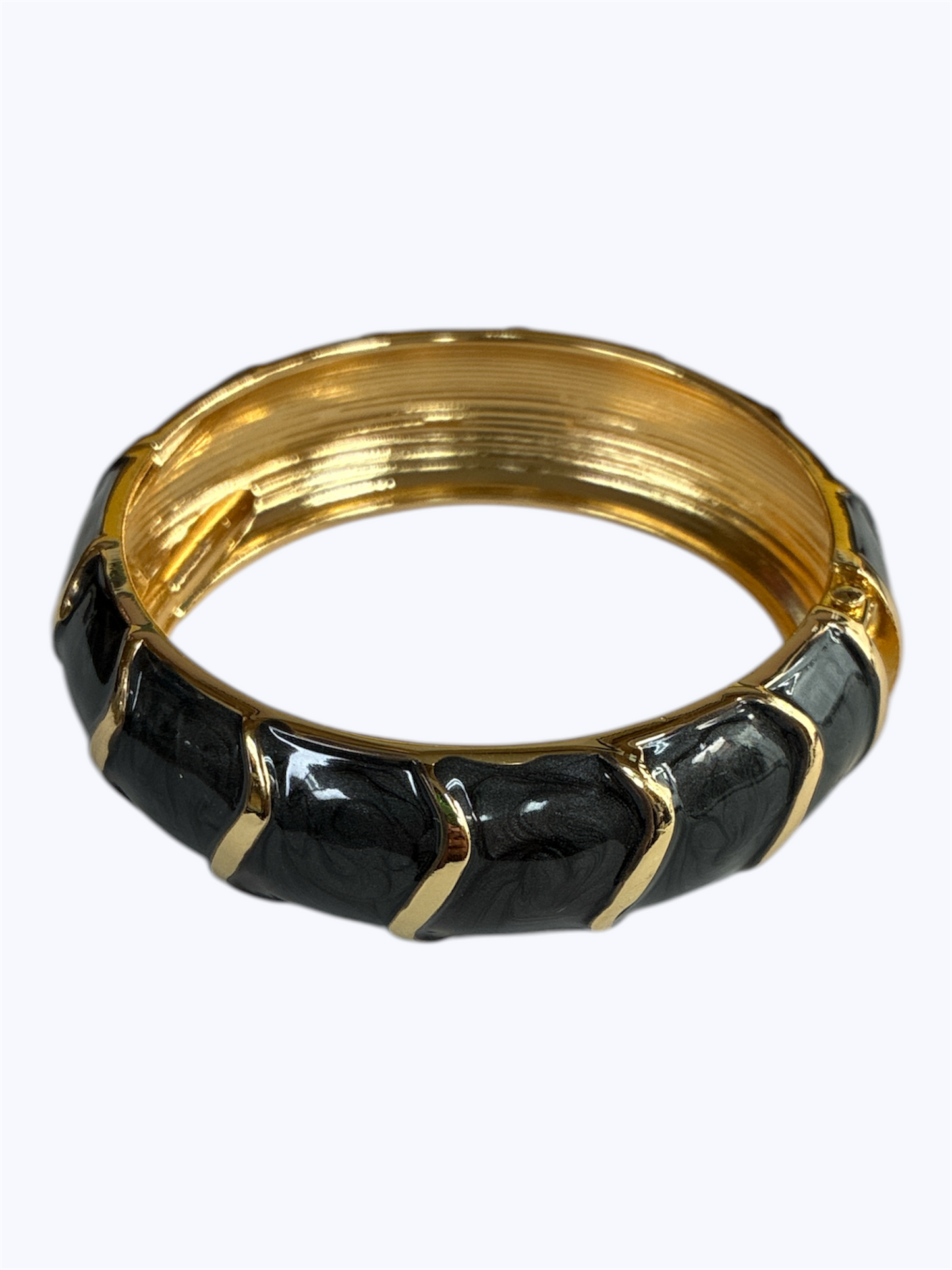 Gold and black bangle on a white background