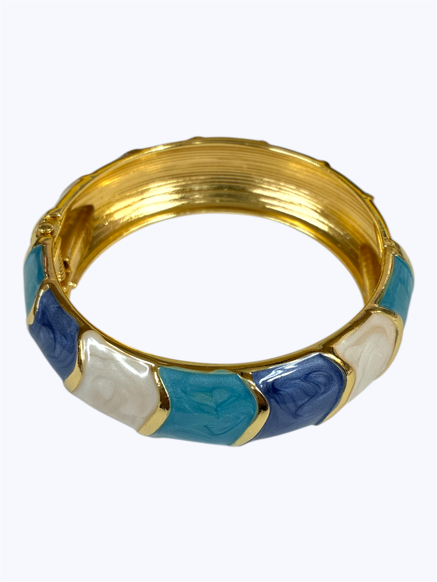 Gold bangle with blue and white sections on a white background