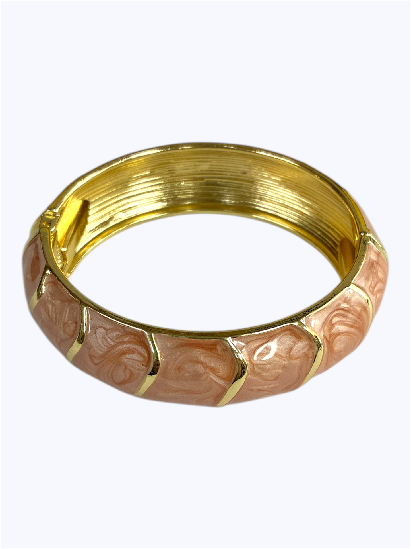 Gold and rose gold bangle with intricate design on a white background
