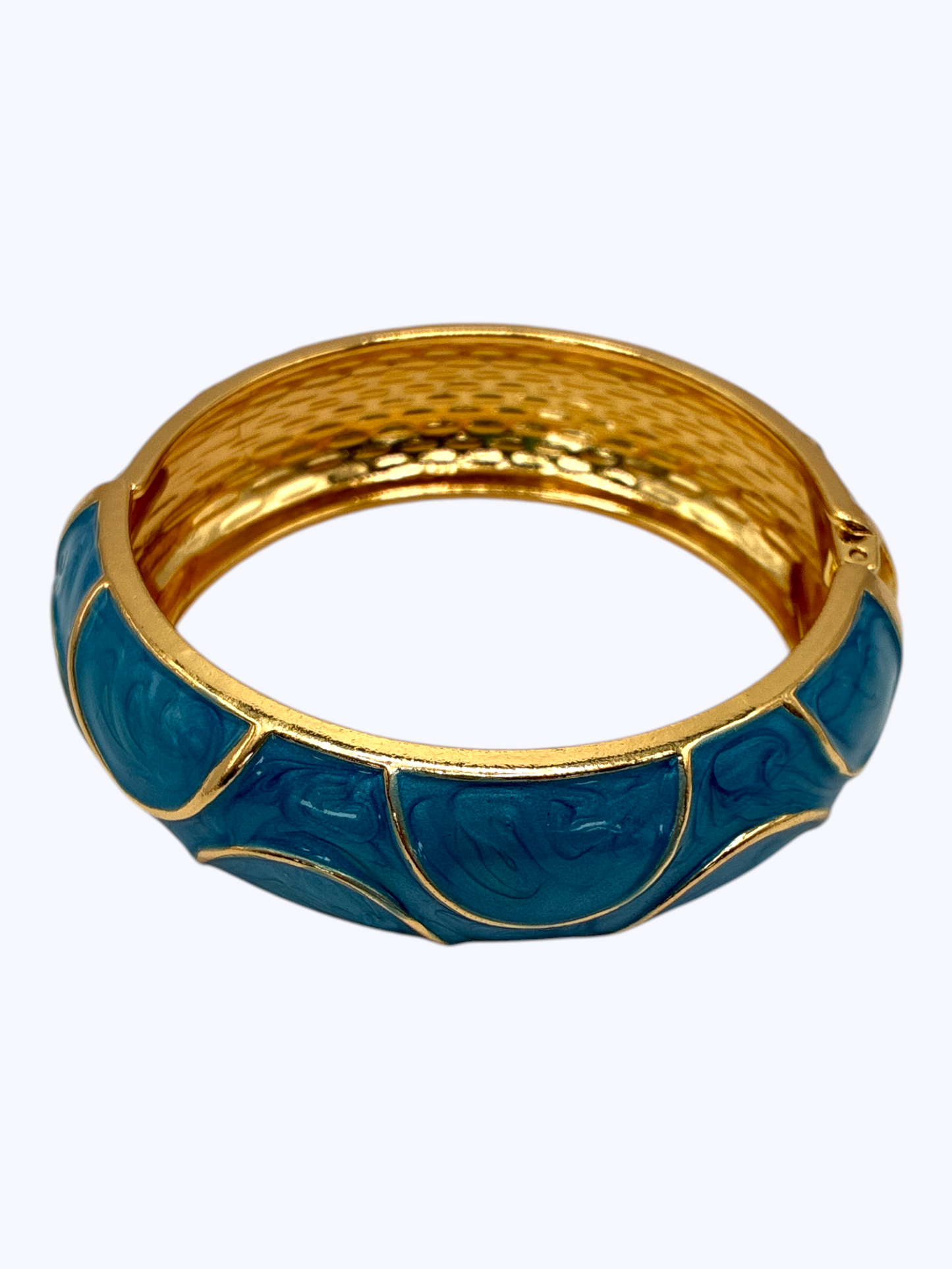 Gold-tone hinged bangle bracelet with glossy blue enamel accents and textured metallic finish for a bold boutique-inspired look.