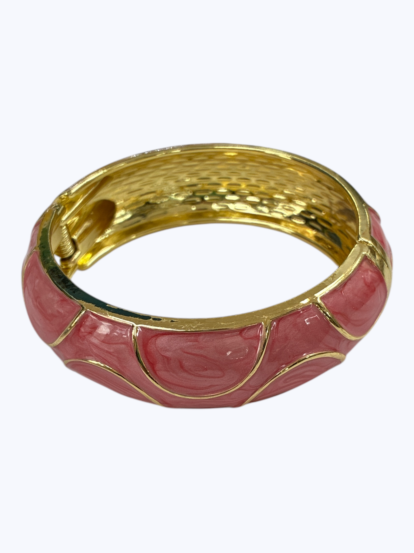 Gold-tone hinged bangle bracelet with glossy pink enamel accents and textured metallic finish for a chic boutique-inspired look.