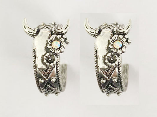 Pair of silver hoop earrings with intricate designs on a light gray background