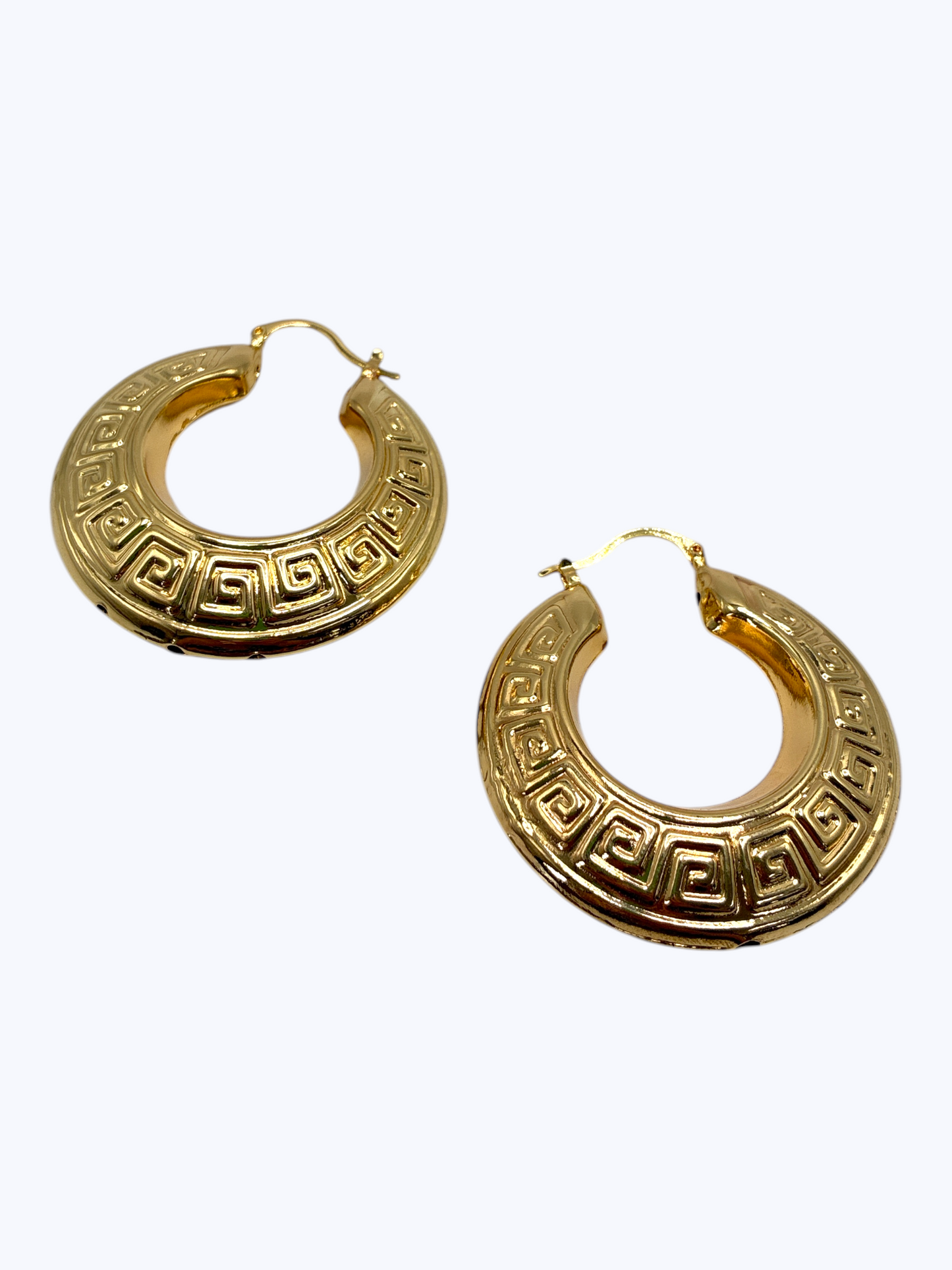 Bold engraved hoop earrings featuring circular metal design with decorative Greek key pattern detailing.