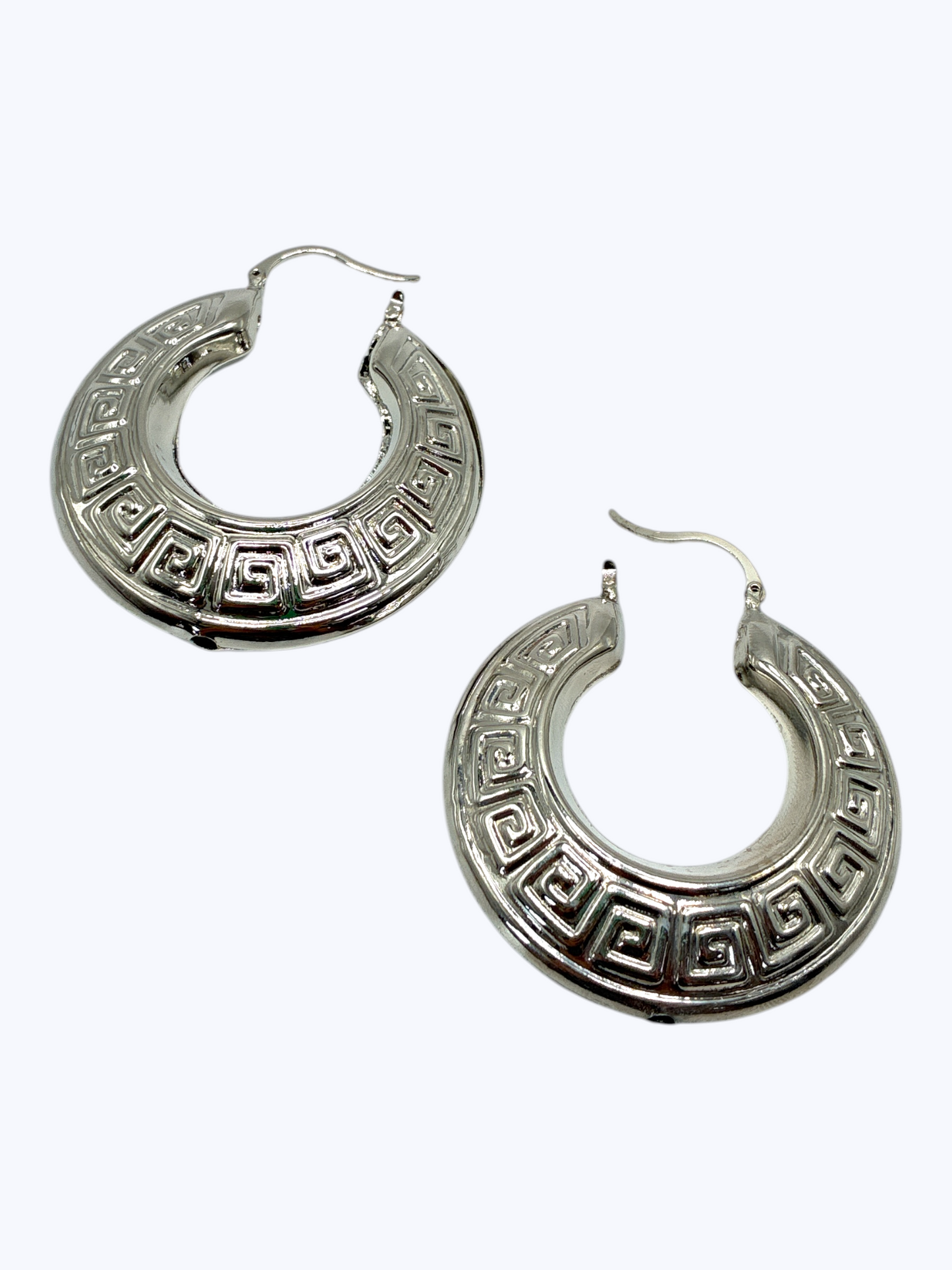 Bold engraved hoop earrings featuring circular metal design with decorative Greek key pattern detailing.