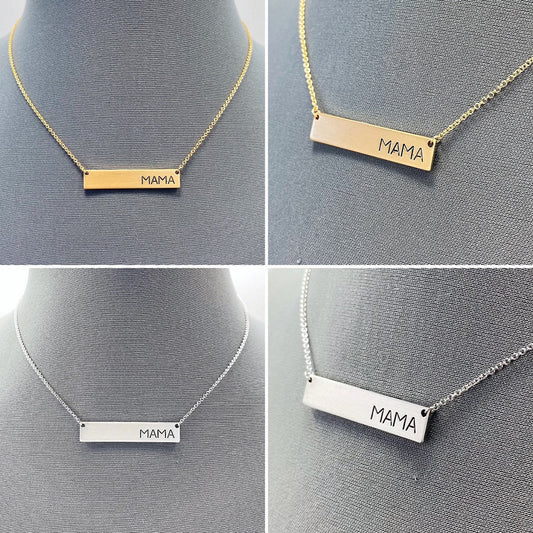 A collection of four necklaces with metal bars engraved with the word 'MAMA', displayed on a mannequin. Two necklaces are gold-colored, and two are silver-colored.