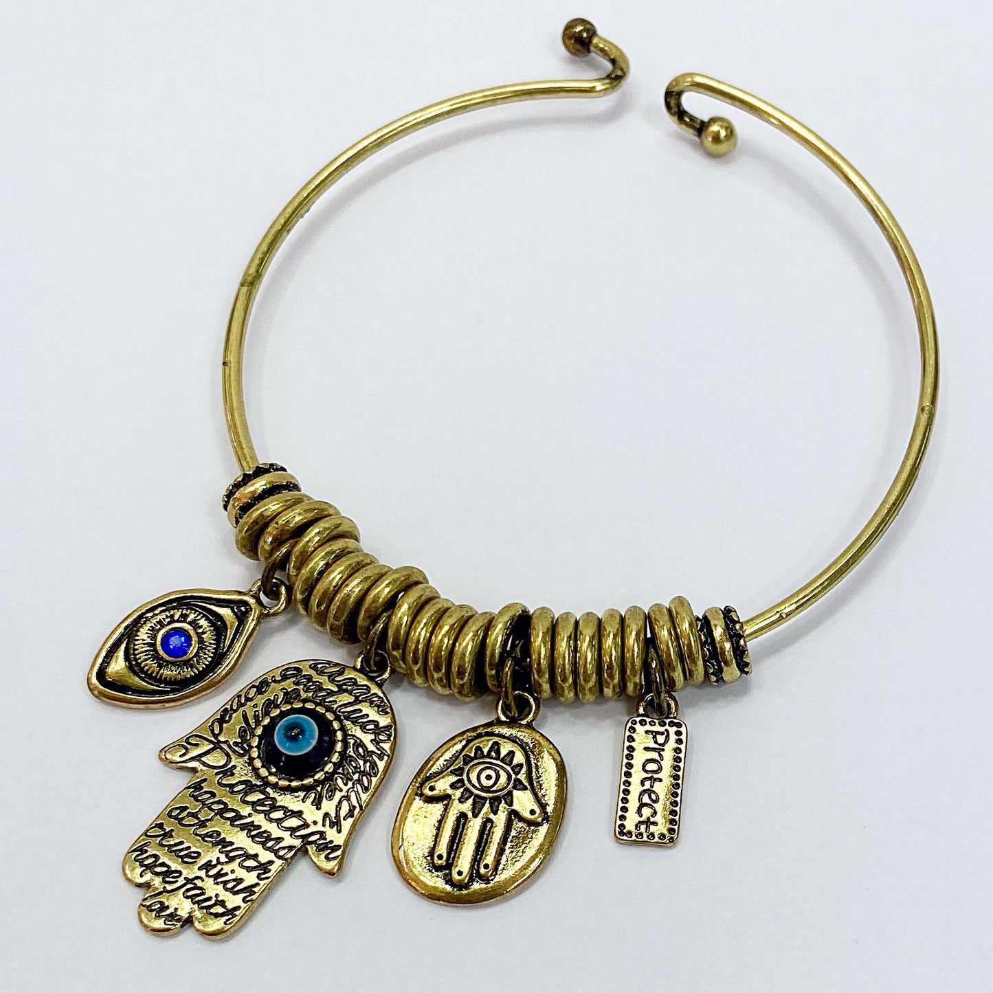 Open cuff bracelet featuring evil eye, hamsa hand, and protection charms with decorative metal accents