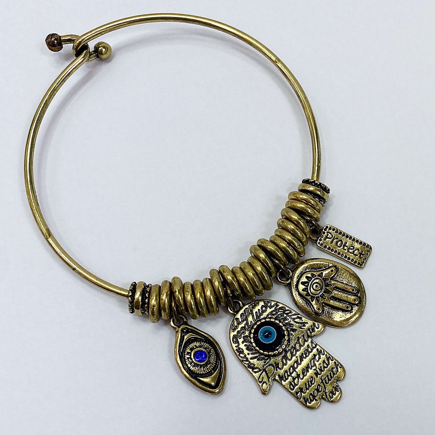 Open cuff bracelet featuring evil eye, hamsa hand, and protection charms with decorative metal accents
