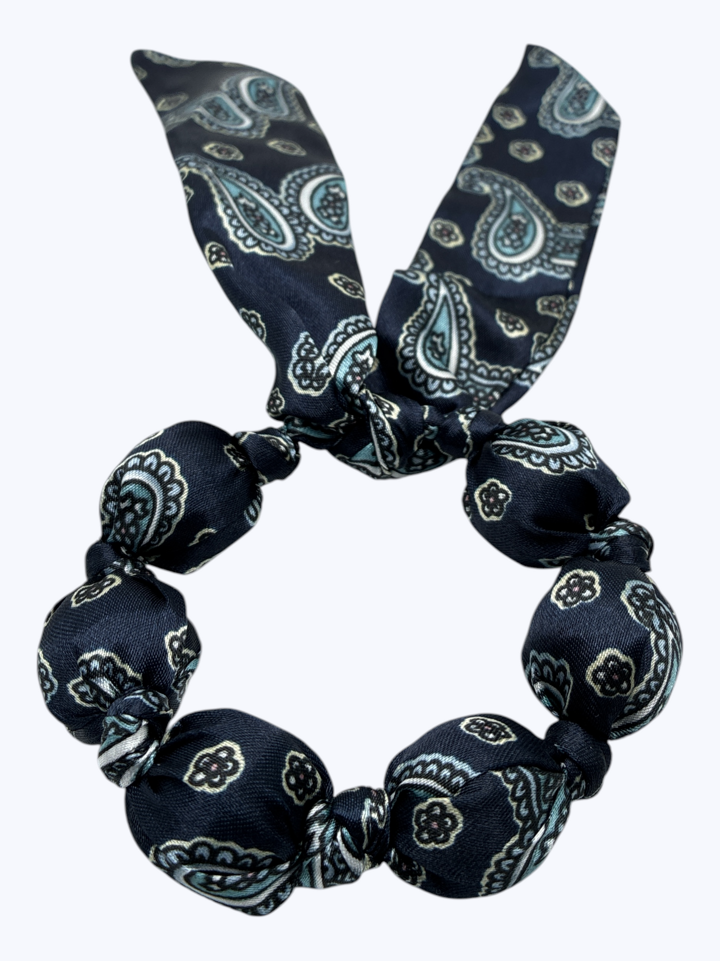 Navy blue paisley patterned hair scrunchie on a white background